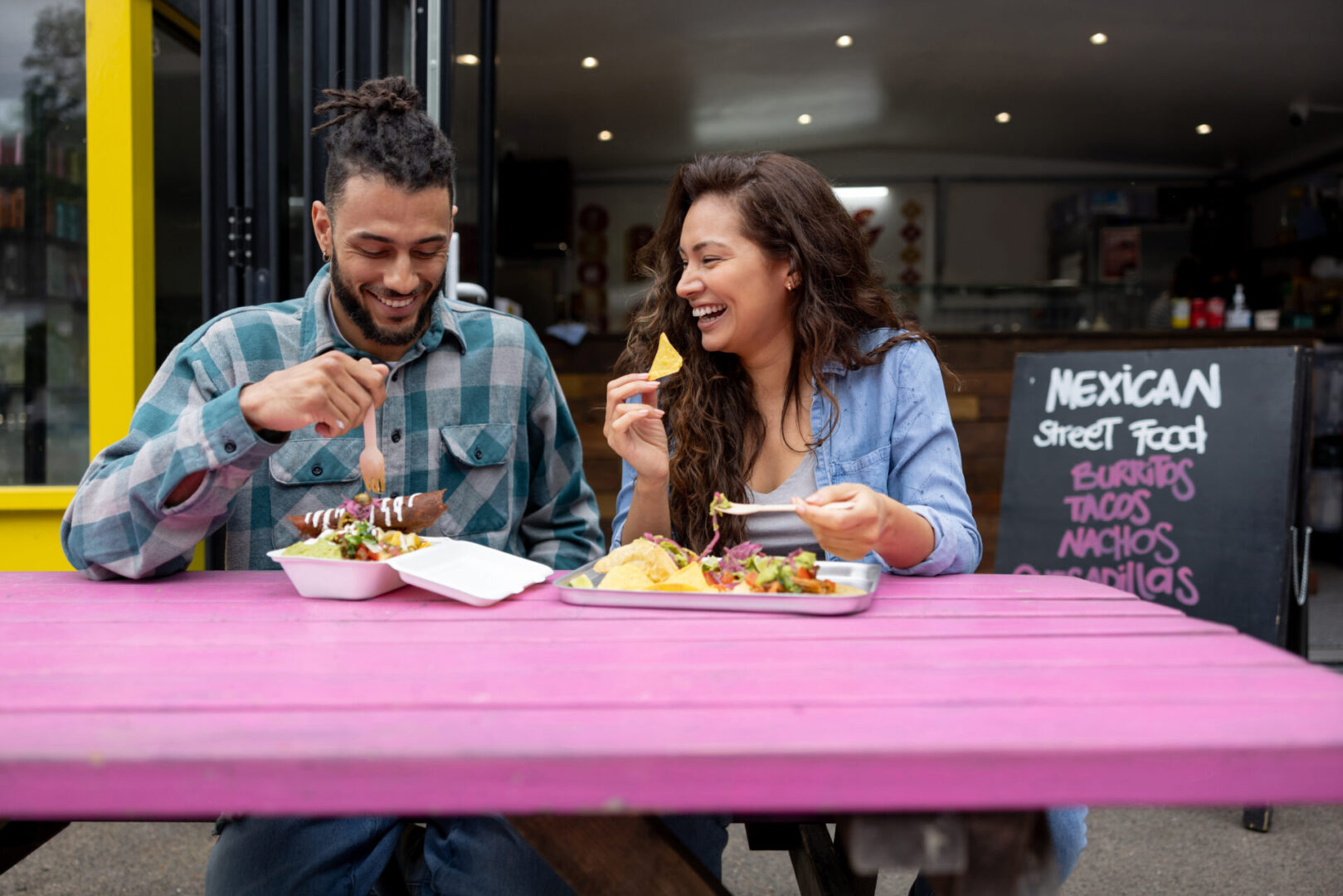 Couple enjoying Mexican street food outdoors